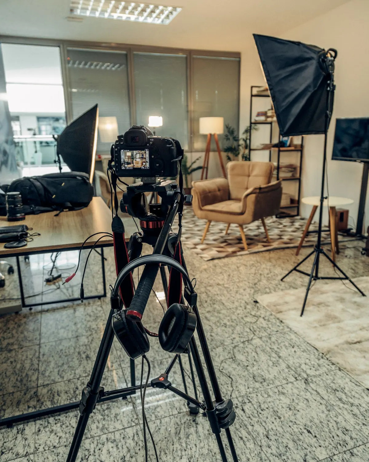 Caméra sur trépied face à un fauteuil éclairé dans un studio de conversation